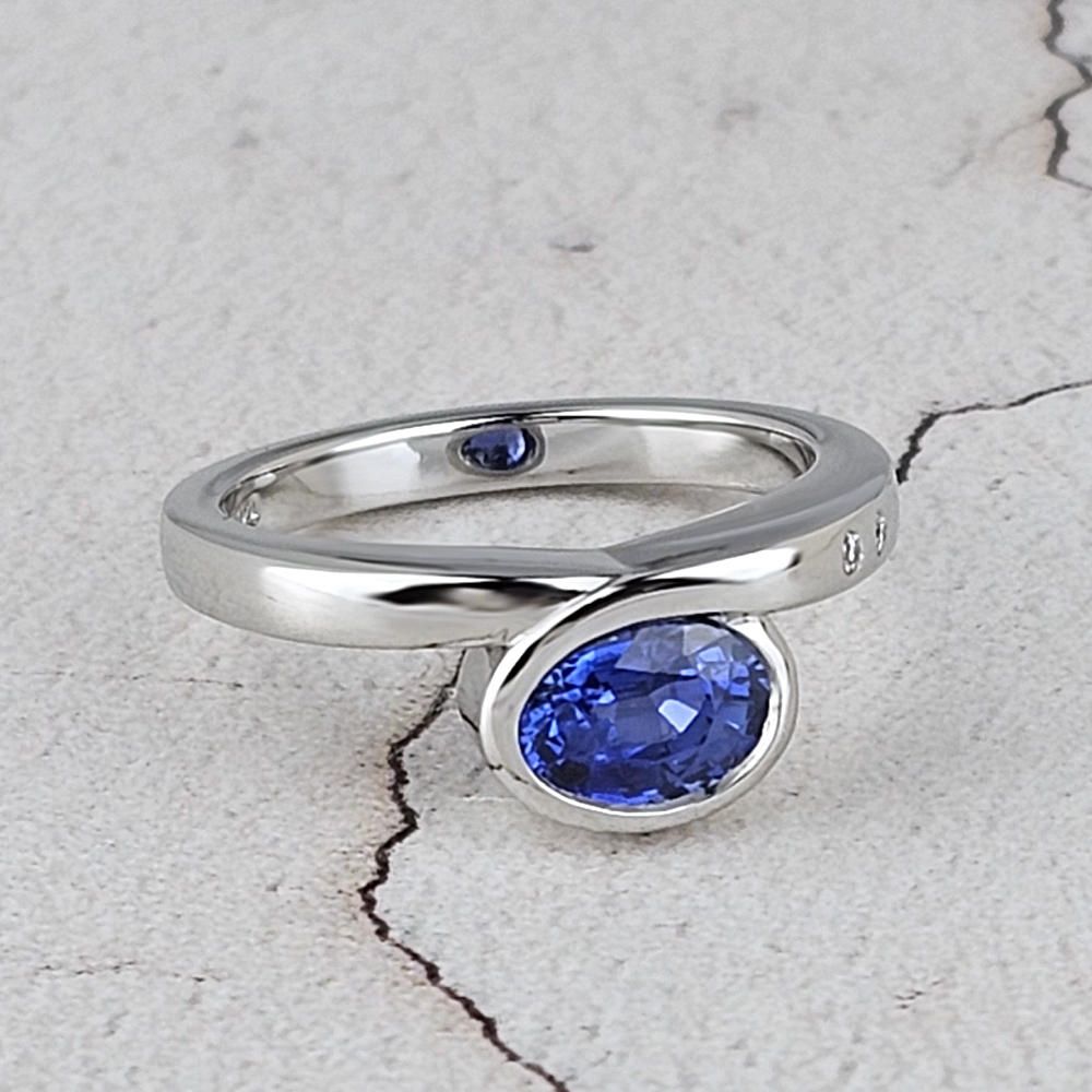An infinity ring with an oval blue sapphire Unique sapphire engagement ring designed and made in Worthing
