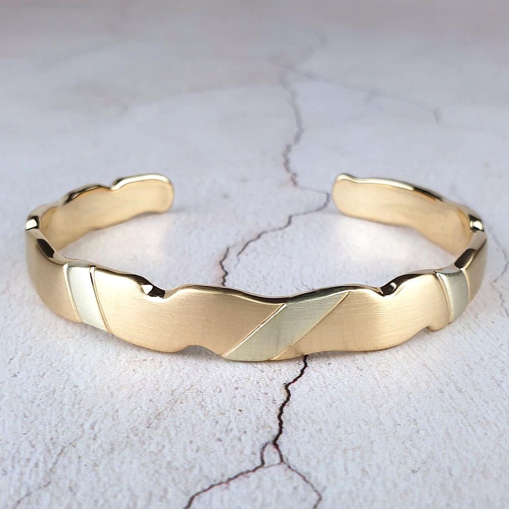 Yellow gold torc with white gold stripes