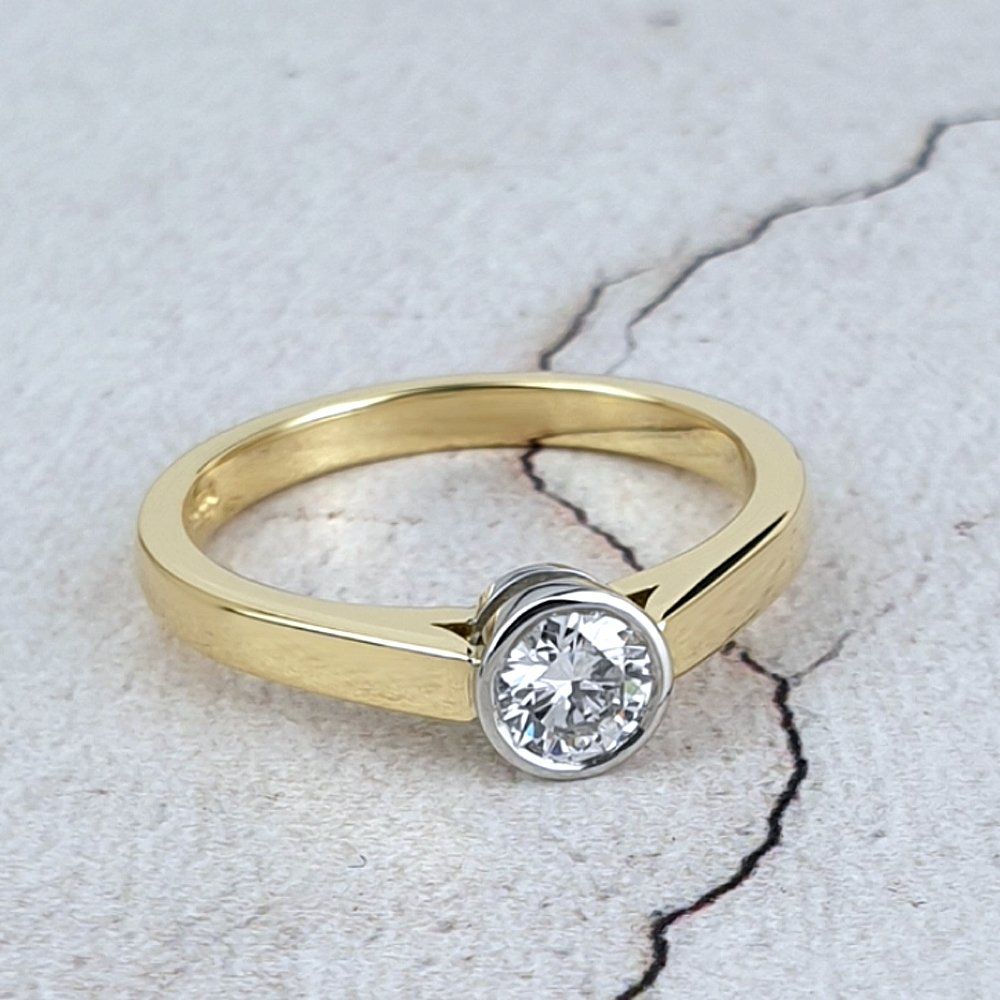 a simple diamond solitaire ring in gold and platinum