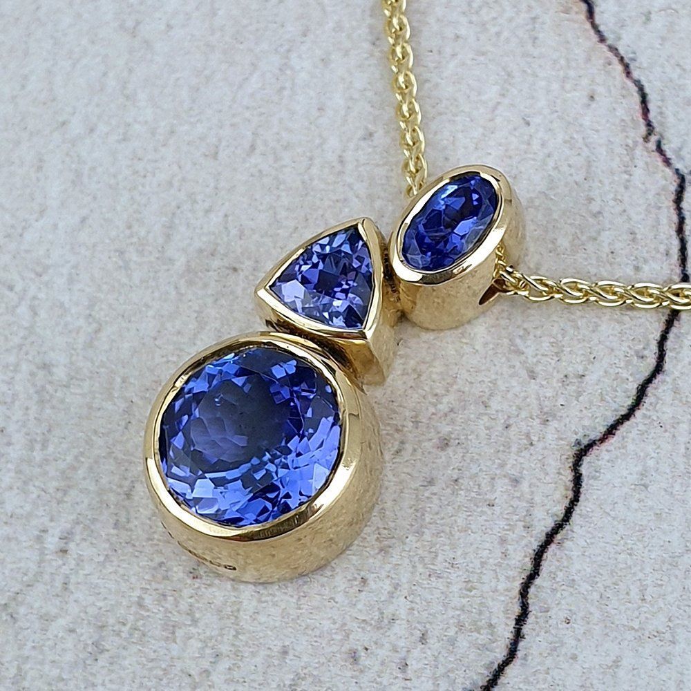 Asymmetric pendant with three Tanzanites set in gold