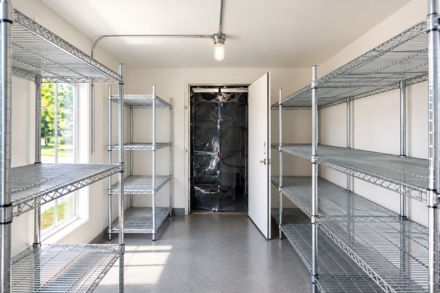 Empty storage room with metal shelving and a window on the left