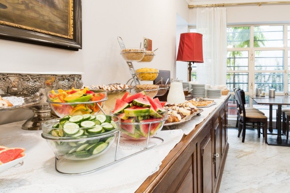 Buffet table with fruits, pastries, and cereals in a dining area.