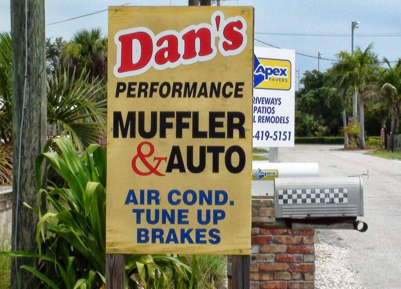 Dan’s Performance Muffler & Auto roadside sign with blue air cond., tune up and brakes text