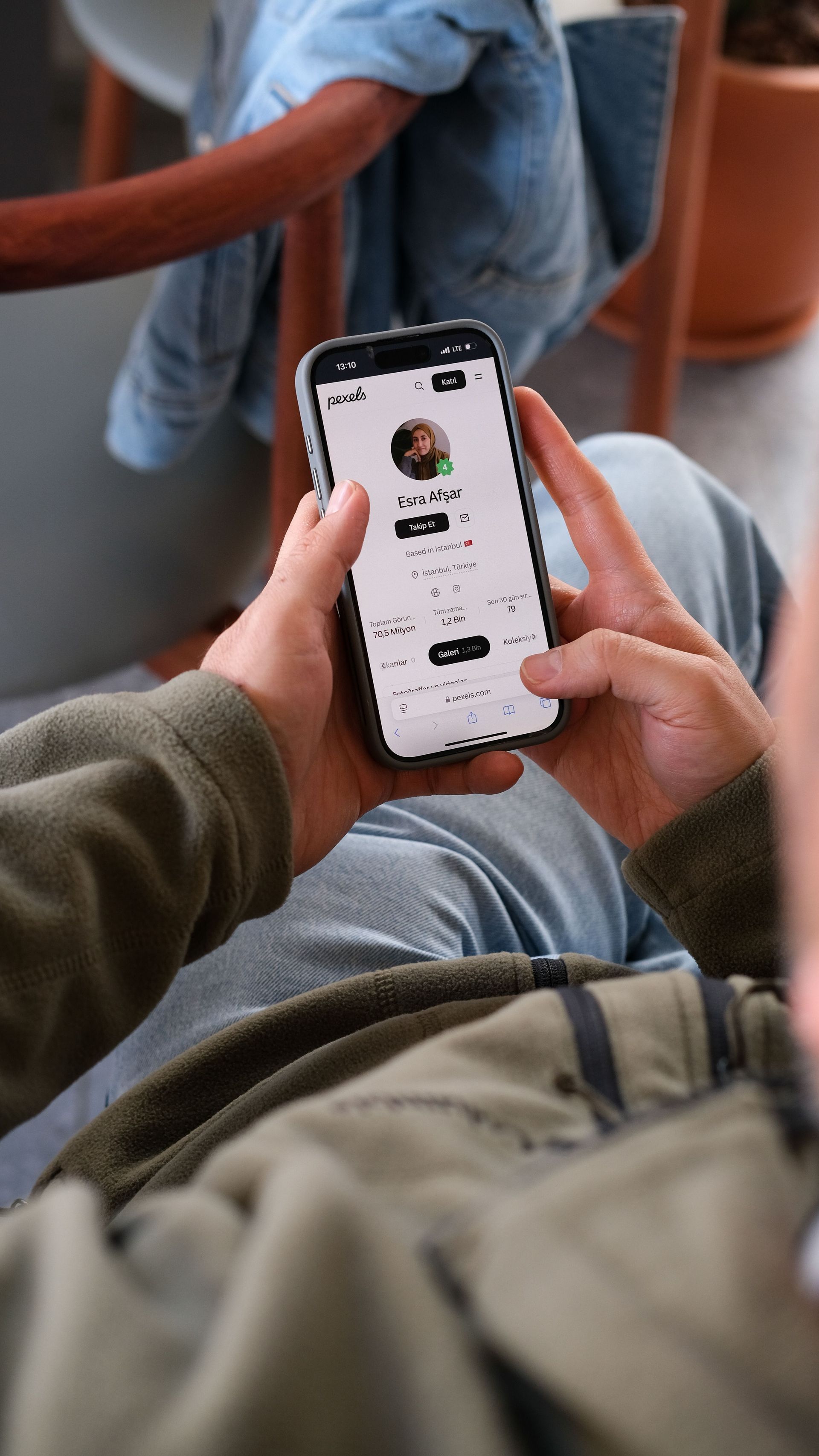 Person using a smartphone with a chat app while sitting indoors on a chair