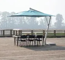 Patio deck with black wicker seating, red cushions, fire pit table, and large umbrella