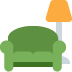 Green armchair with a tall orange floor lamp beside it