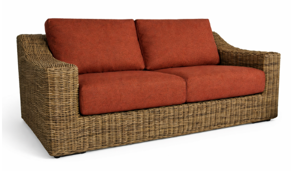 Brown wicker loveseat with orange cushions on a white background