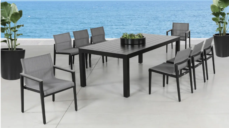 Black patio dining set with chairs and table on a seaside terrace