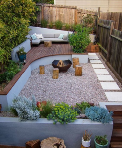 Backyard patio with gravel fire pit, curved wooden seating, white sofa, and potted plants