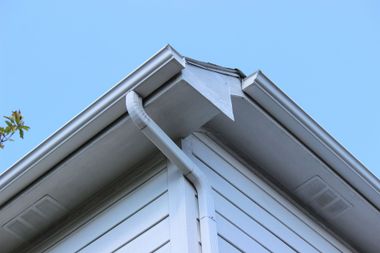 A white house with a gutter on the roof