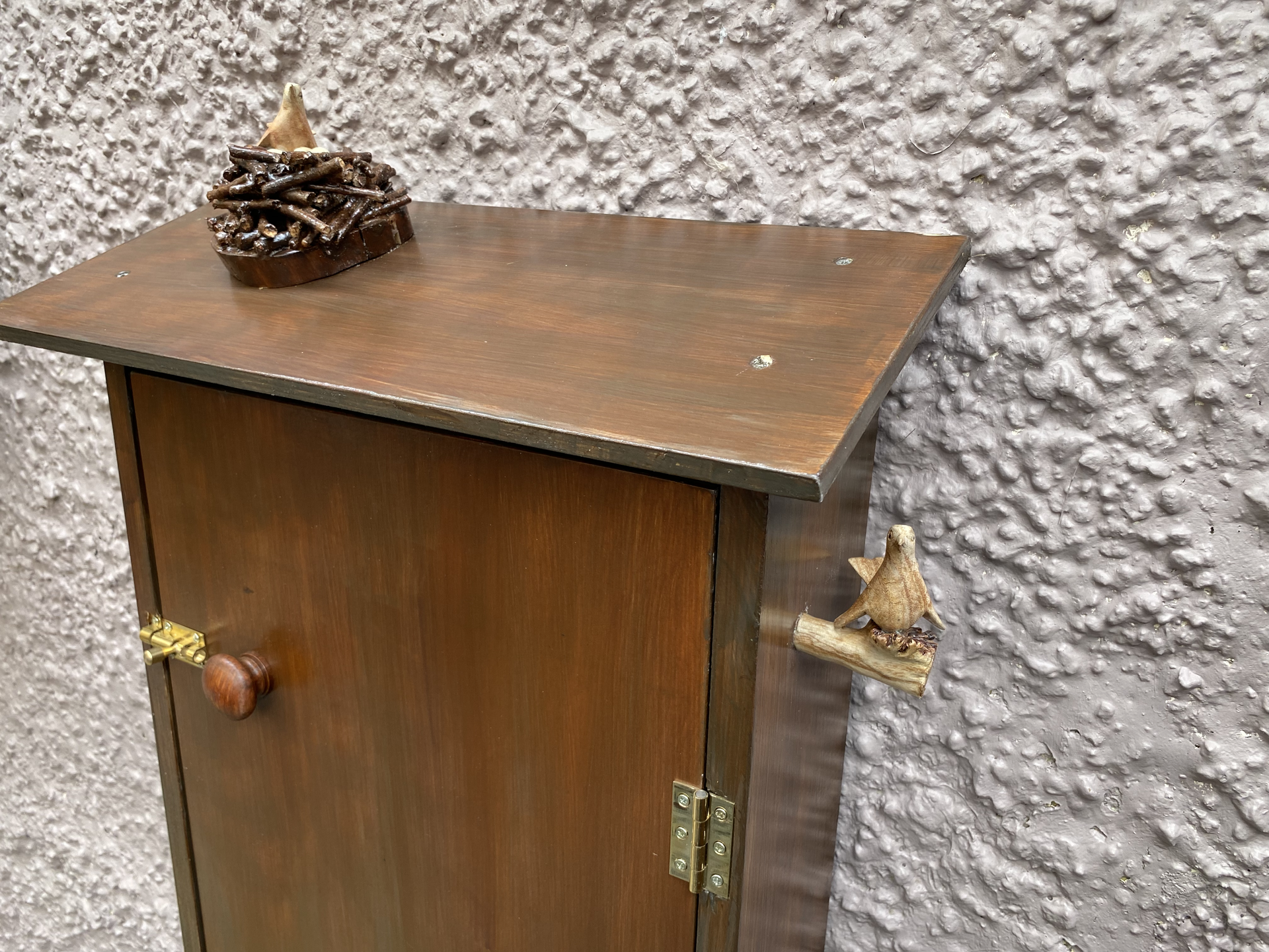 Hose cabinet decorated with wooden birds