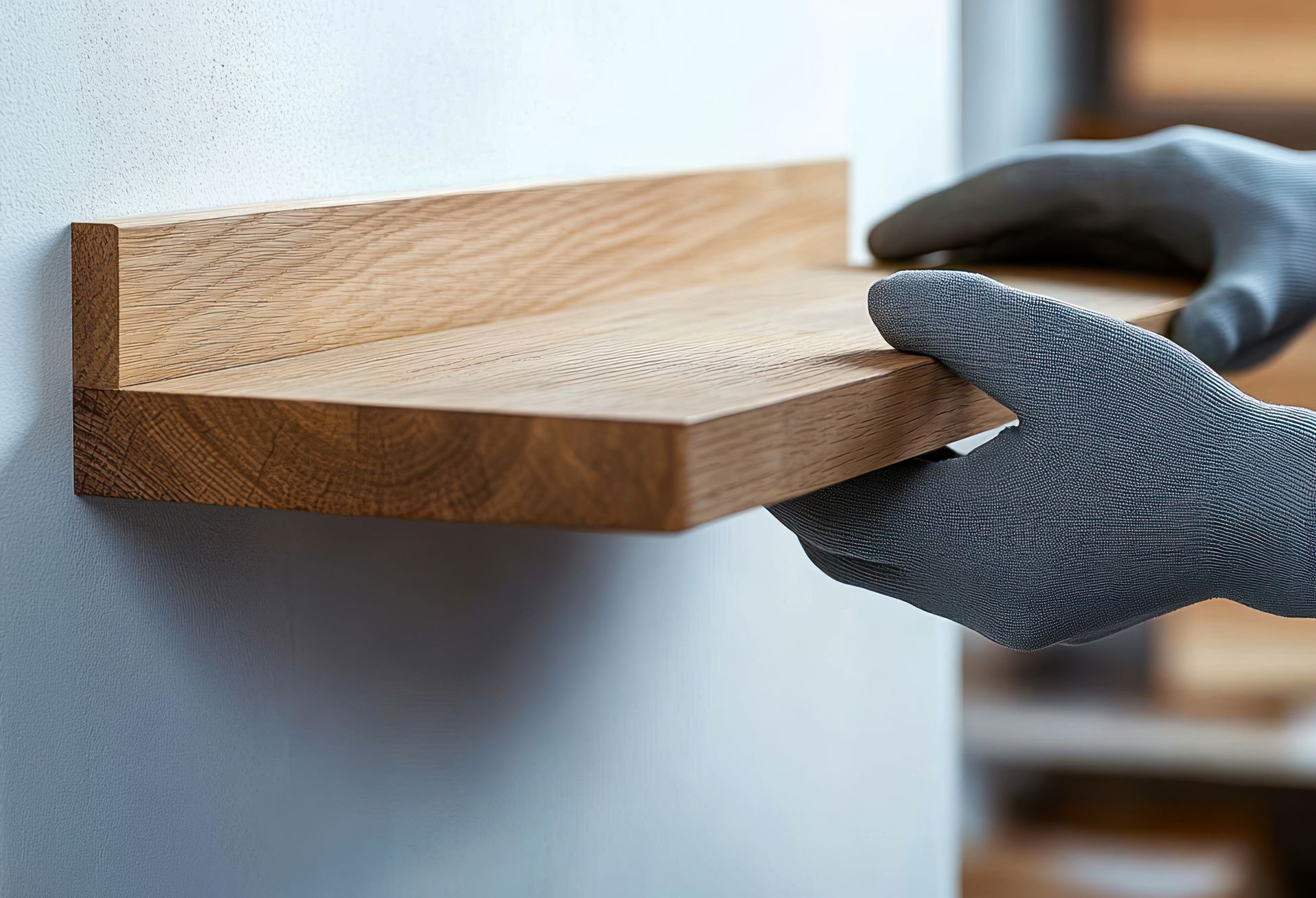 Hands positioning shelf against a wall