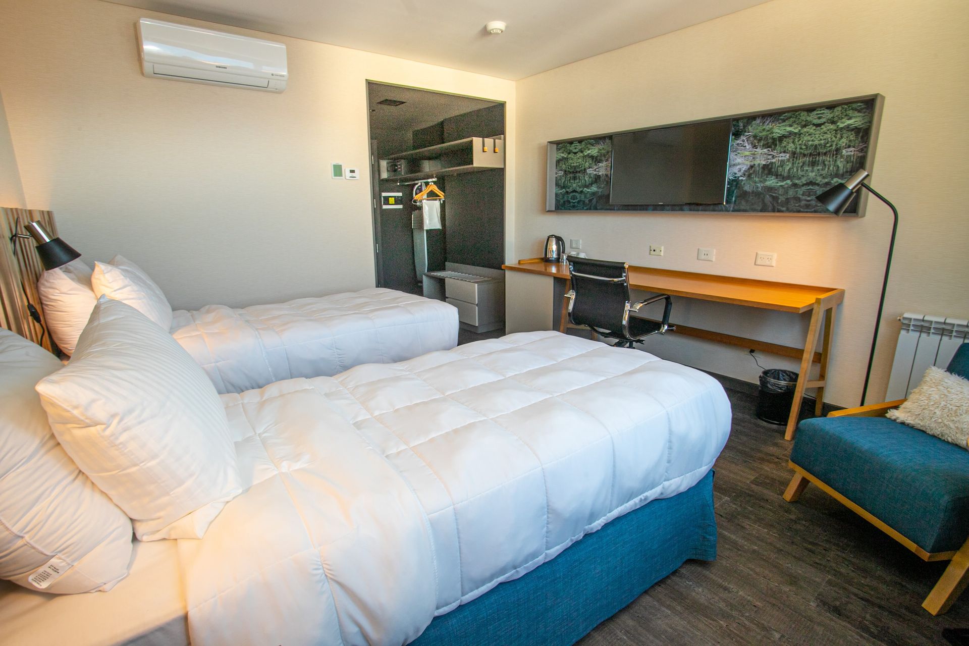Una habitación de hotel con dos camas, un escritorio y una silla.