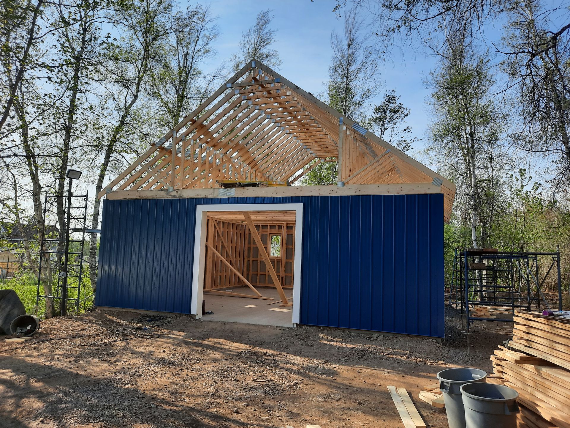 A blue building with a wooden roof is being built.