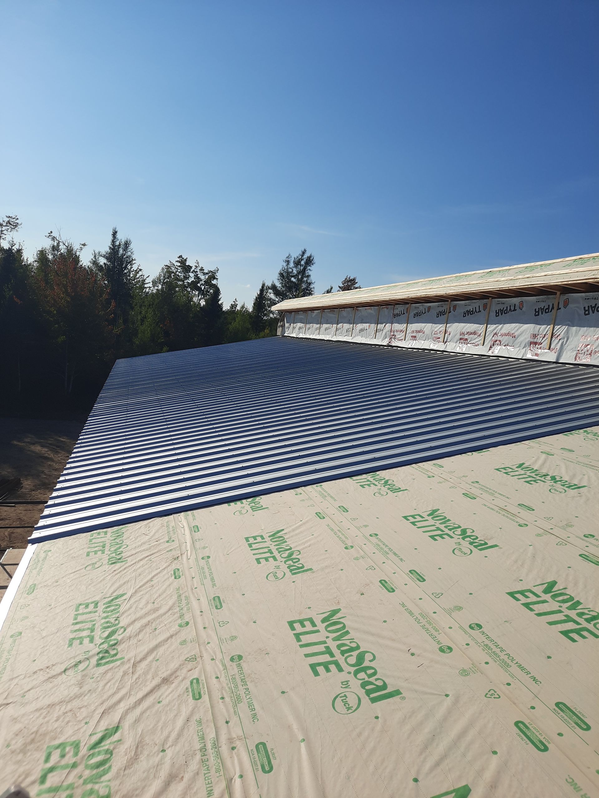 A roof is being covered with a sheet of insulation.