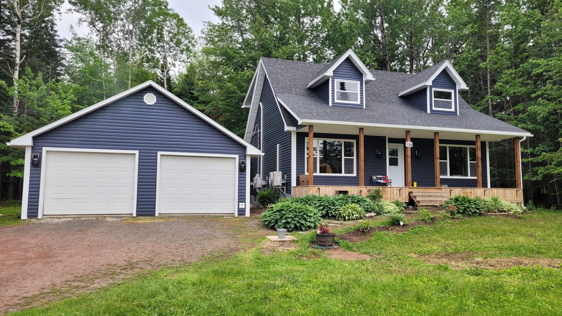 A blue house with a white garage next to it.