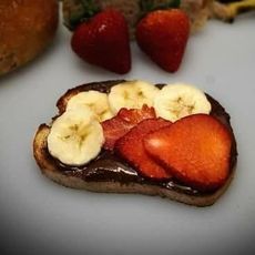 A piece of toast with bananas and strawberries on it.