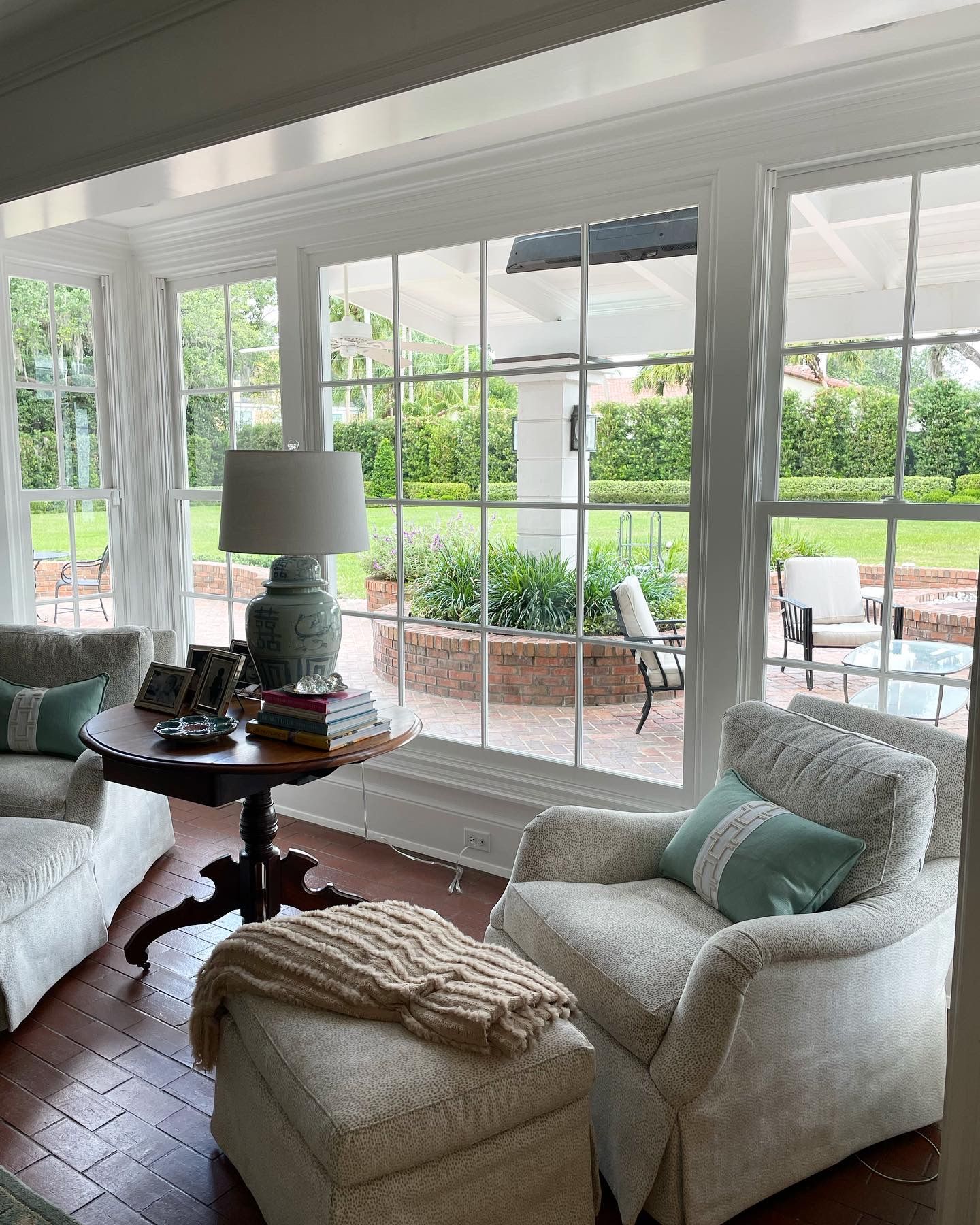 A living room with white furniture and a large window
