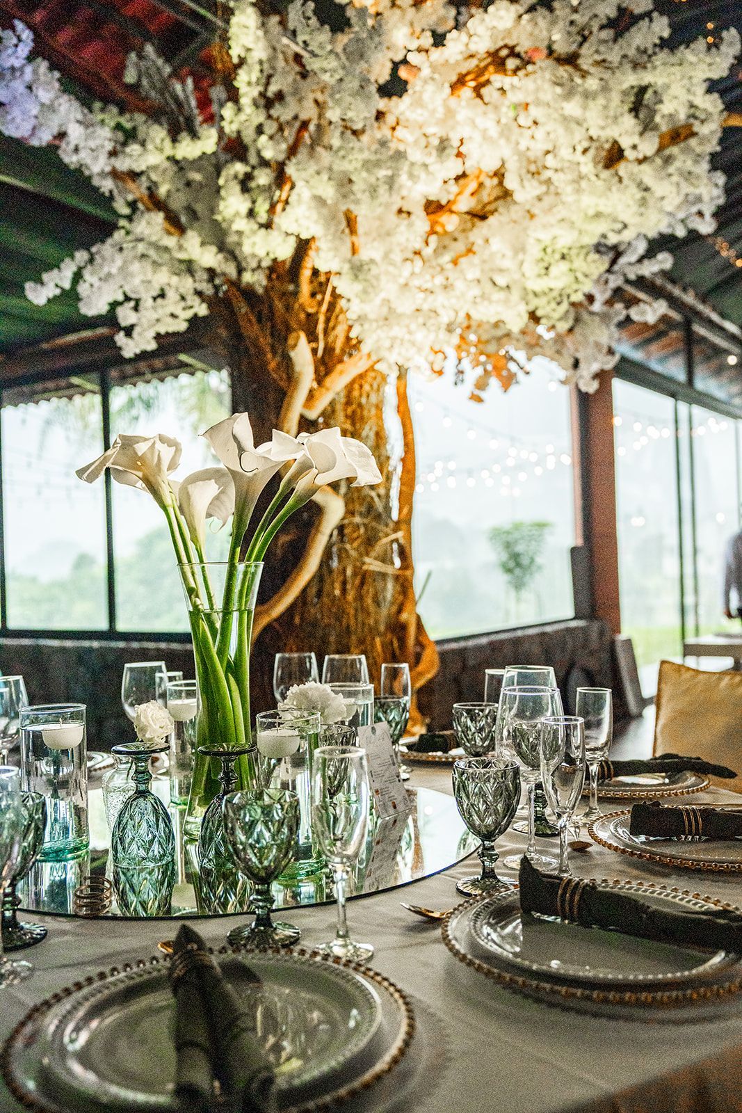 Elegante mesa de banquete con cristalería, centro de mesa floral blanco y decoración a la luz de las velas