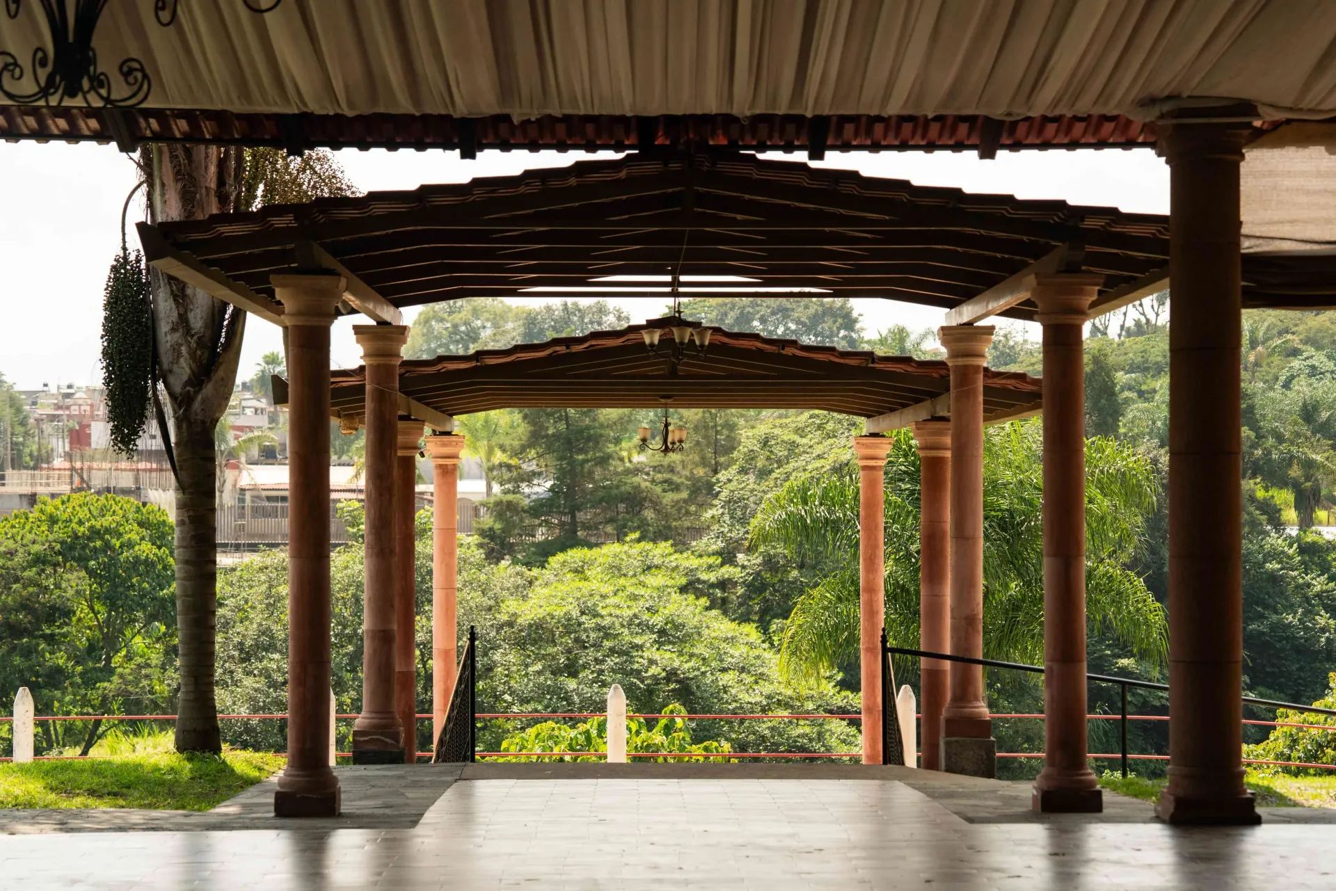 Wooden pergola walkway overlooking lush greenery and garden beyond