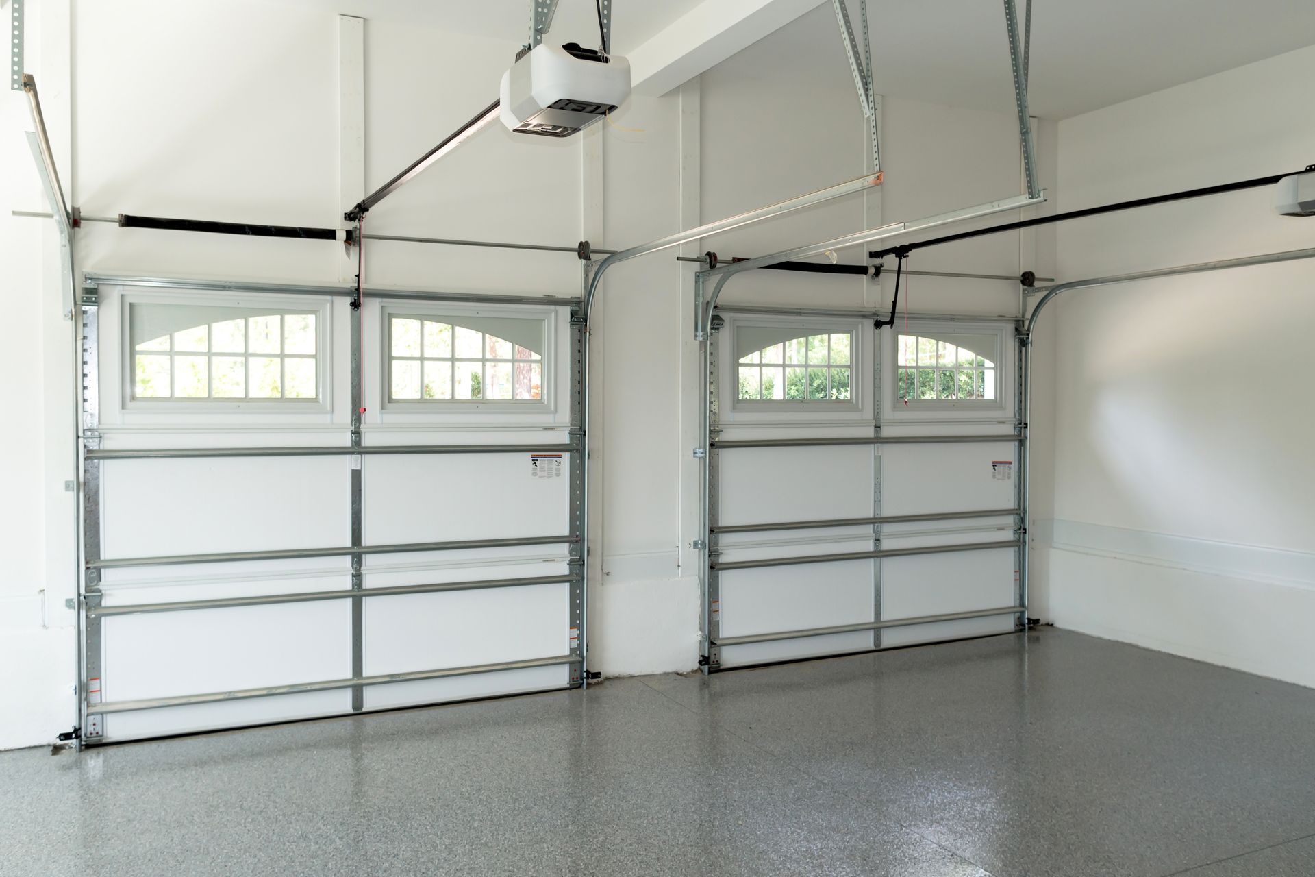 A man is working on a garage door in a garage.