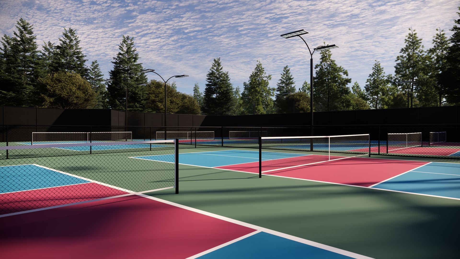 Colorful outdoor court with net, empty. Tall trees and blue sky in background.