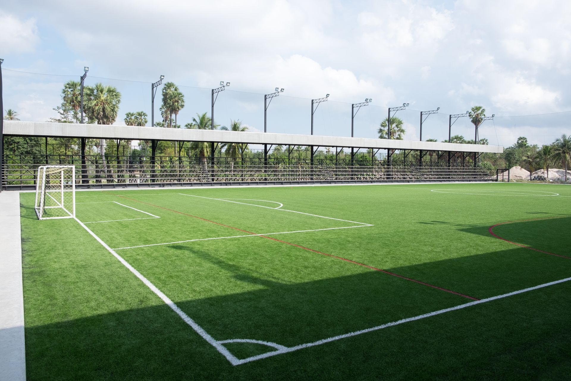 Soccer field with green turf, white lines, a goal, and covered spectator seating.