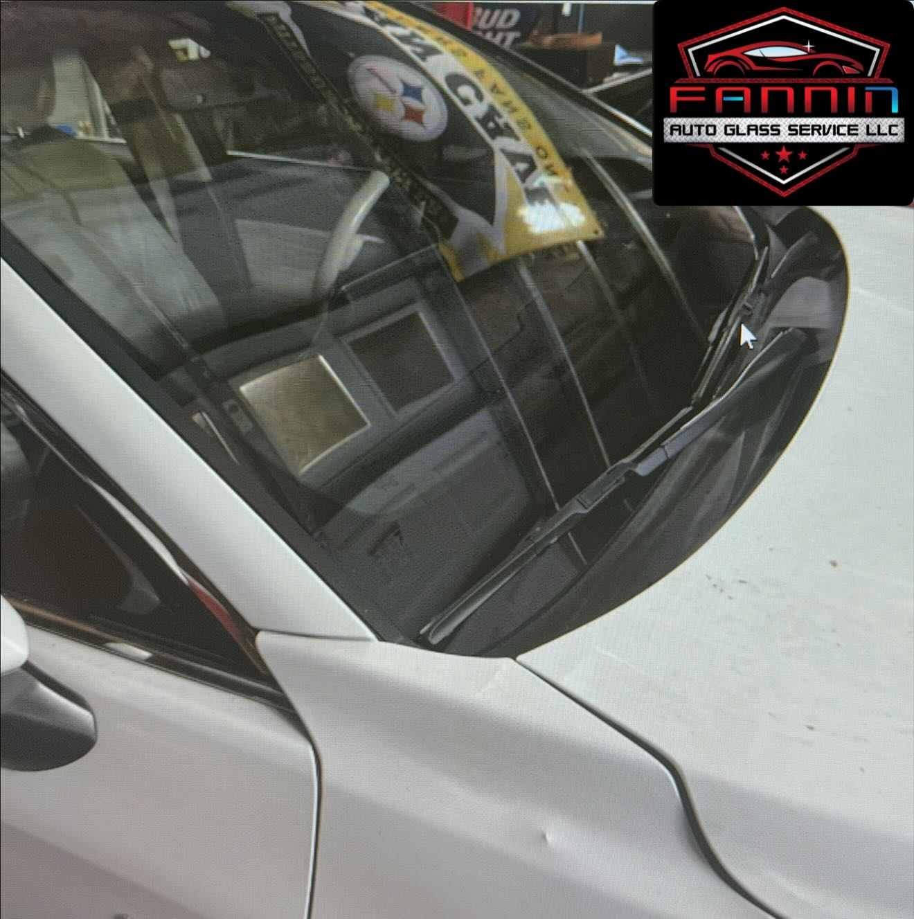 White car windshield with reflections and a Fani Auto Glass Service logo in the corner