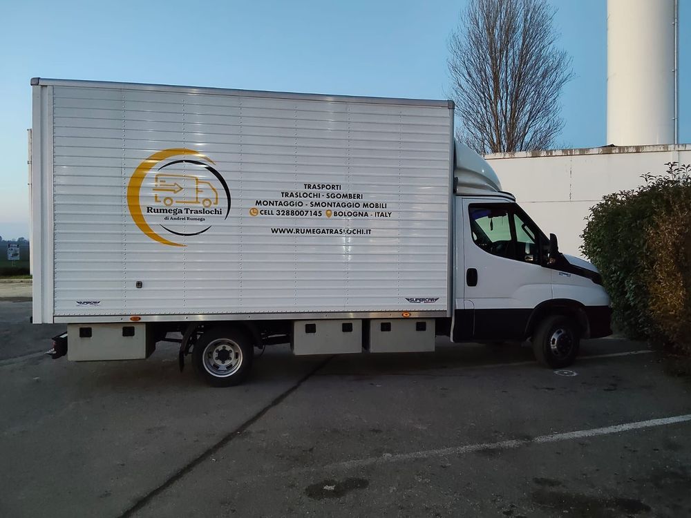 Un camioncino bianco per le consegne è parcheggiato accanto a un edificio in un parcheggio asfaltato.