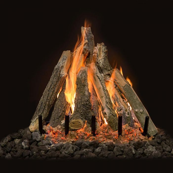 A burning campfire with tall orange flames on stacked logs over dark stones