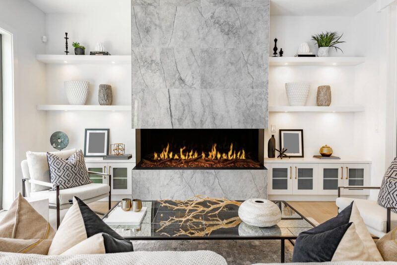 Modern living room with white shelves, marble fireplace, and black-and-gold coffee table