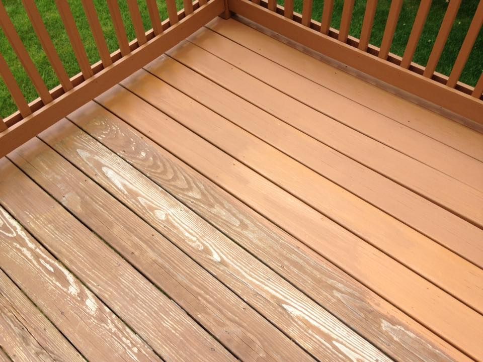 A wooden deck with a railing and a stain on it