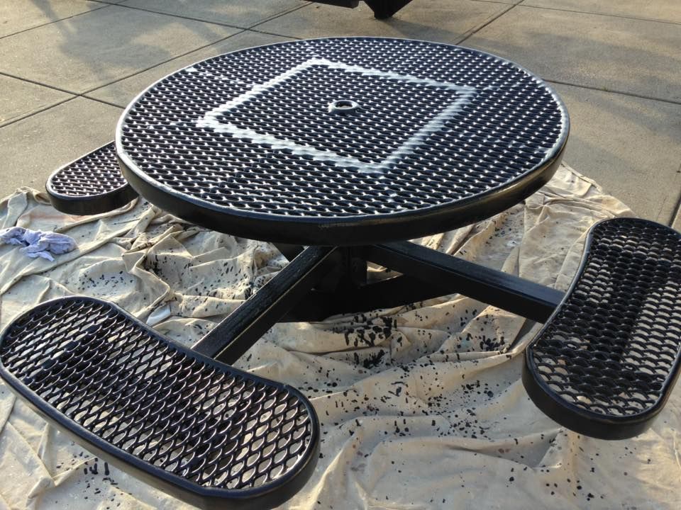 A black picnic table with a square on it