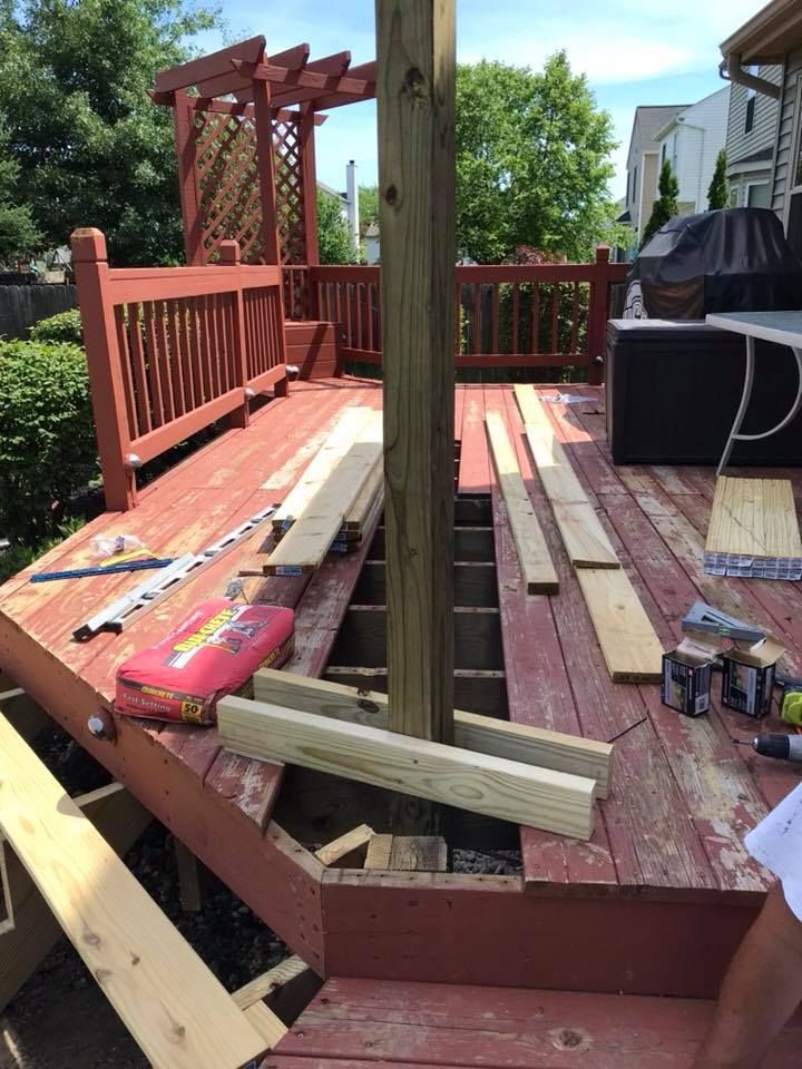 A wooden deck is being built with wooden boards and a drill.