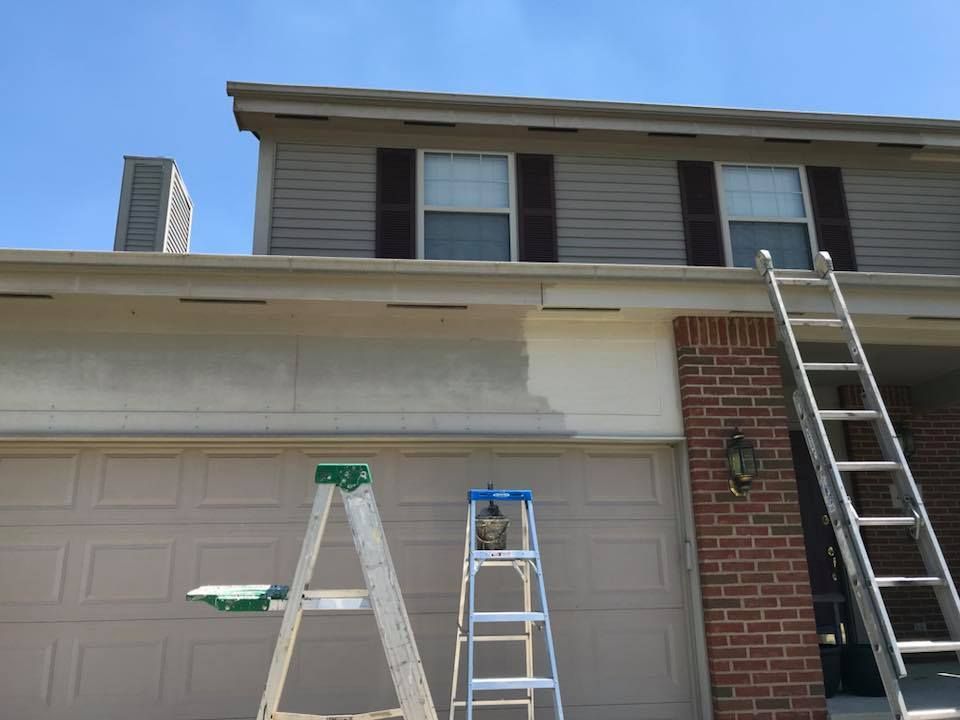 A house is being painted with a ladder in front of it
