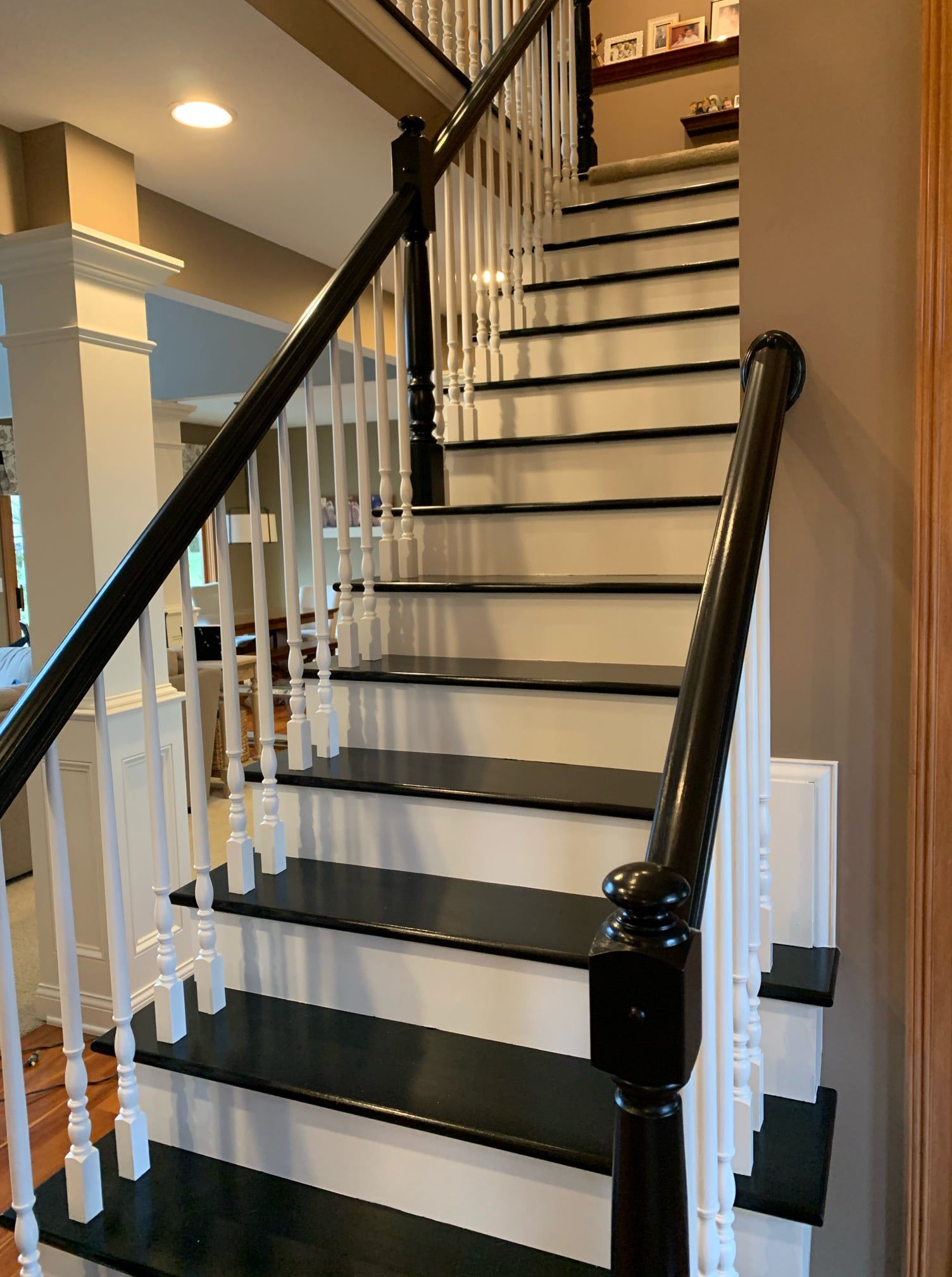 A staircase with black steps and white railings in a house.