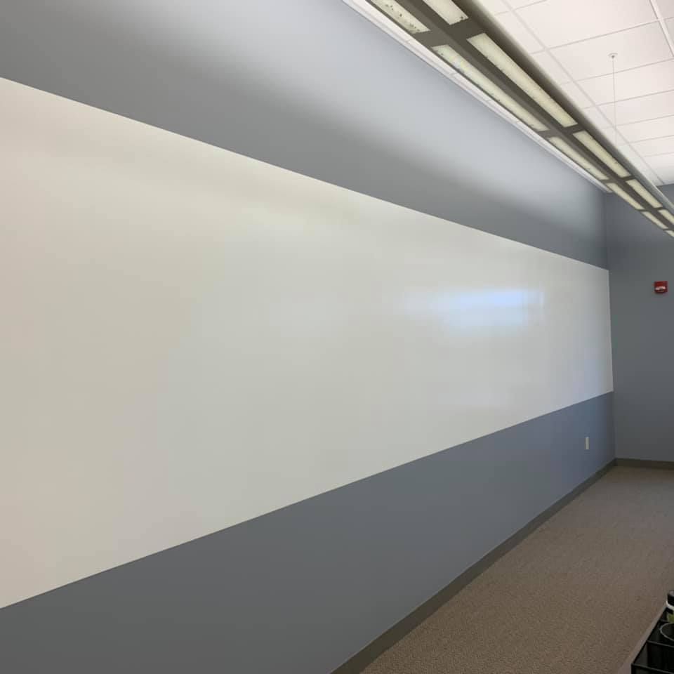 A long hallway with a white board on the wall