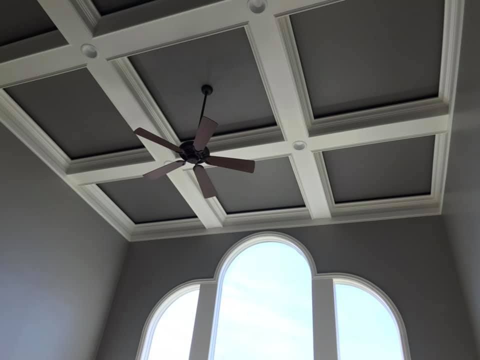 A ceiling fan is hanging from the ceiling of a room.