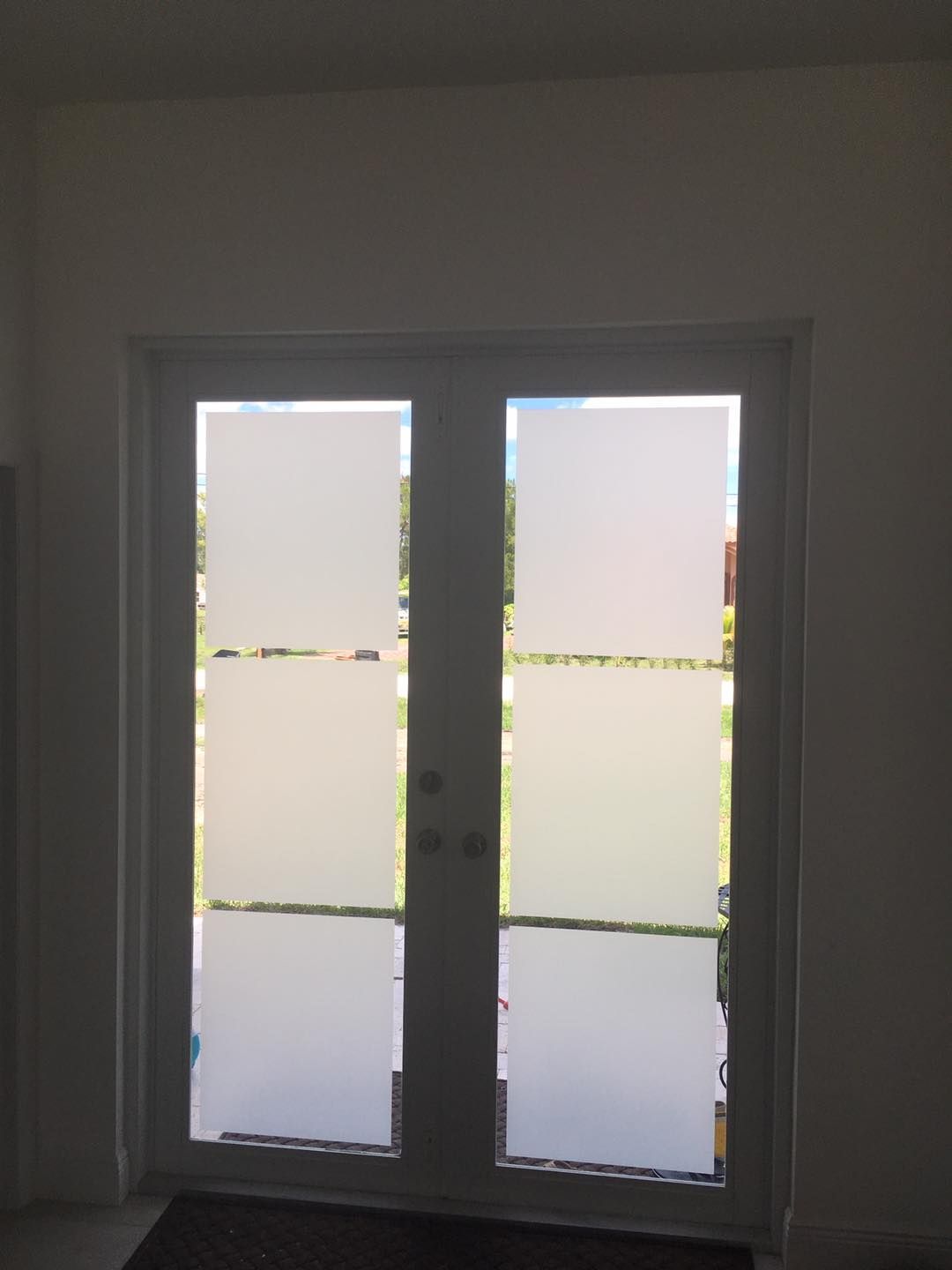 A pair of sliding glass doors with frosted glass in a room.