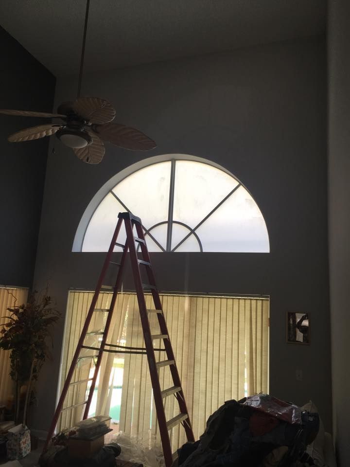 A ladder is sitting in front of a window in a living room