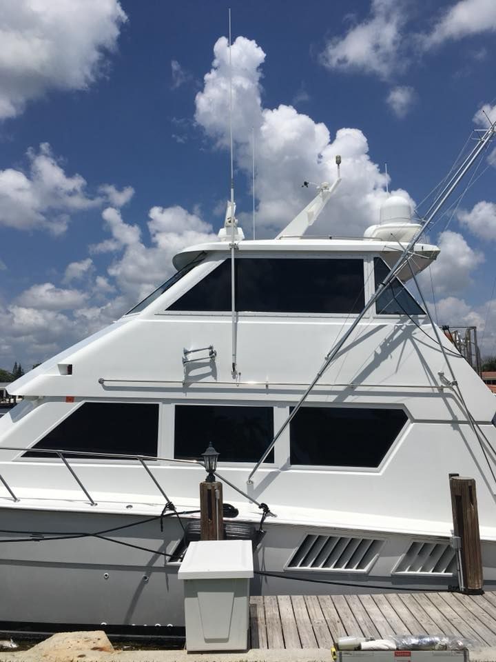 A large white boat is docked at a dock on a sunny day