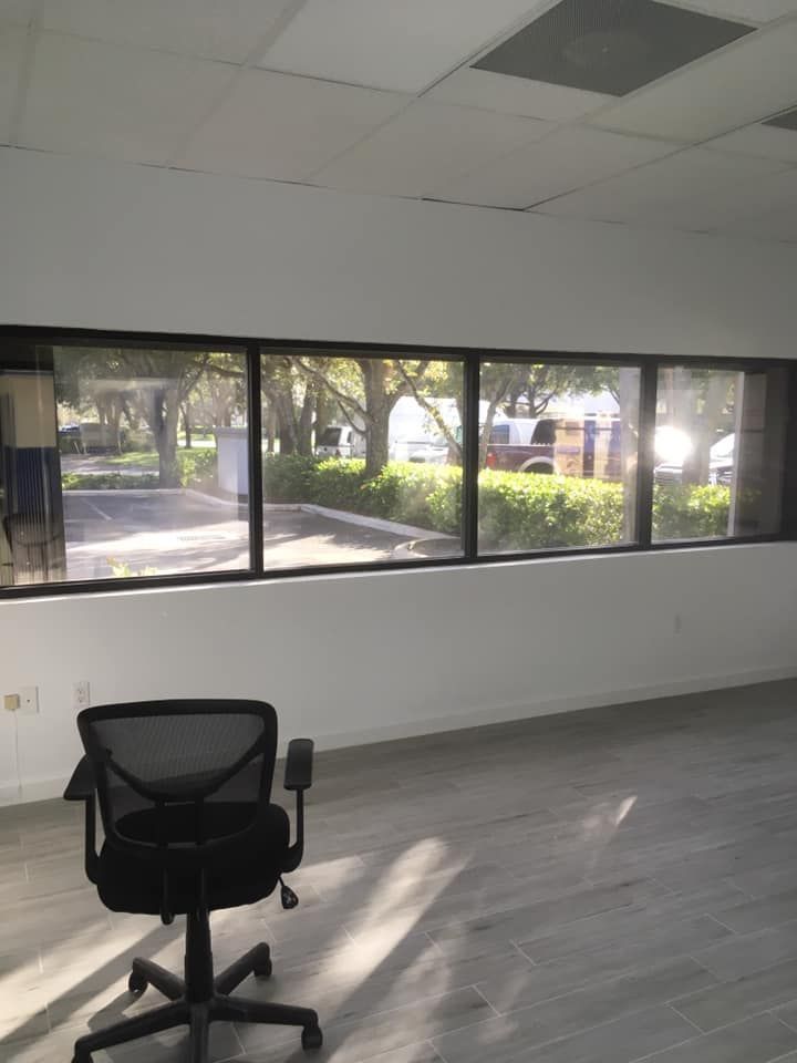 An empty office with a chair and a large window