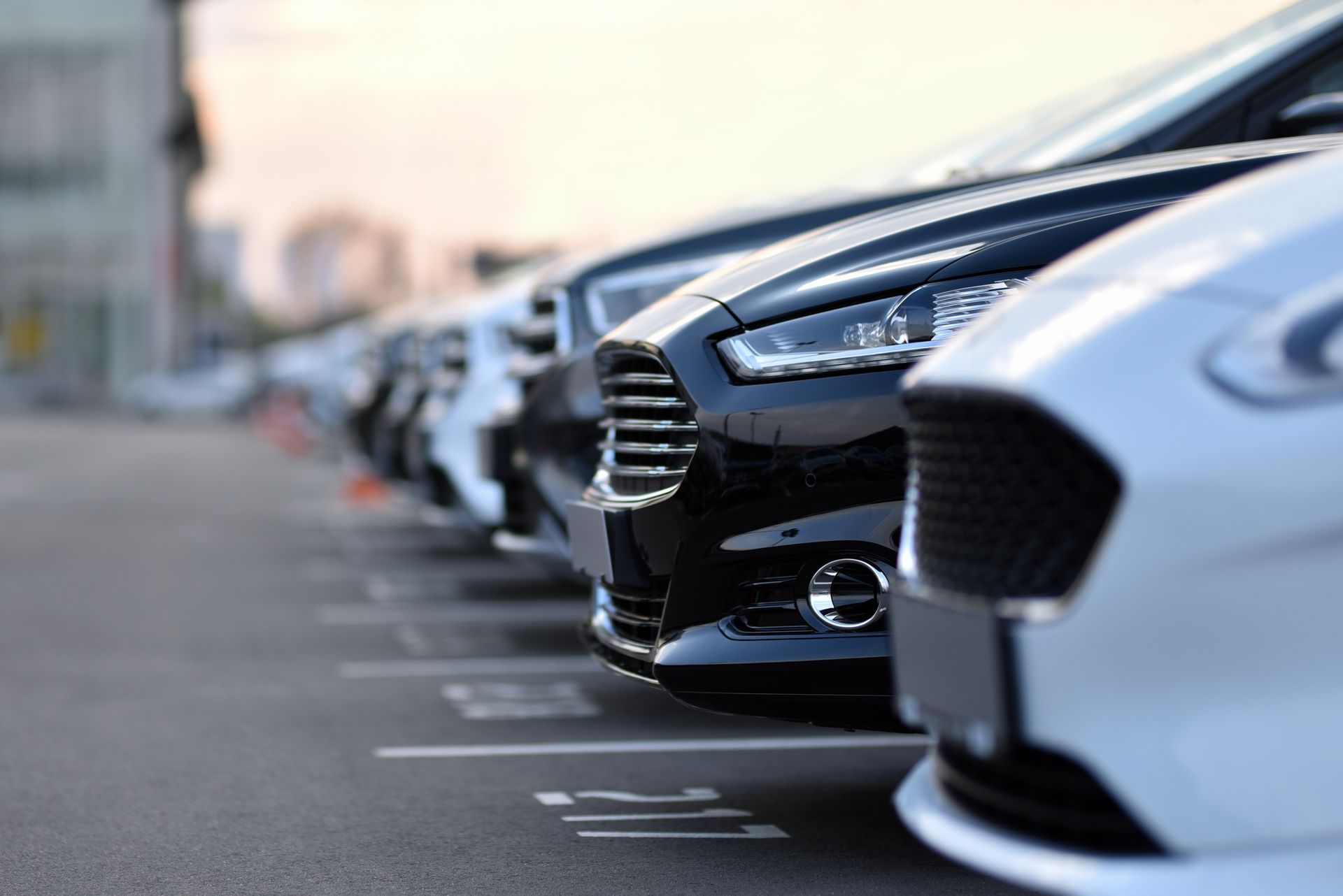 Row of parked cars along a street, with a black SUV in the foreground Row of parked cars along a street, with a black SUV in the foreground
