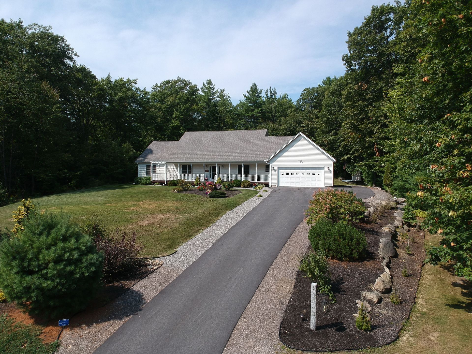 Single-story suburban house with driveway, landscaped front yard, and trees around it. Single-story suburban house with driveway, landscaped front yard, and trees around it.