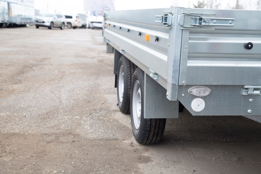 A flatbed trailer is parked in a parking lot — Marx Forster Tyres & Mechanical In Forster, NSW