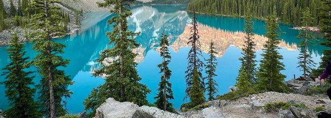 A lake surrounded by trees and rocks in the middle of a forest.