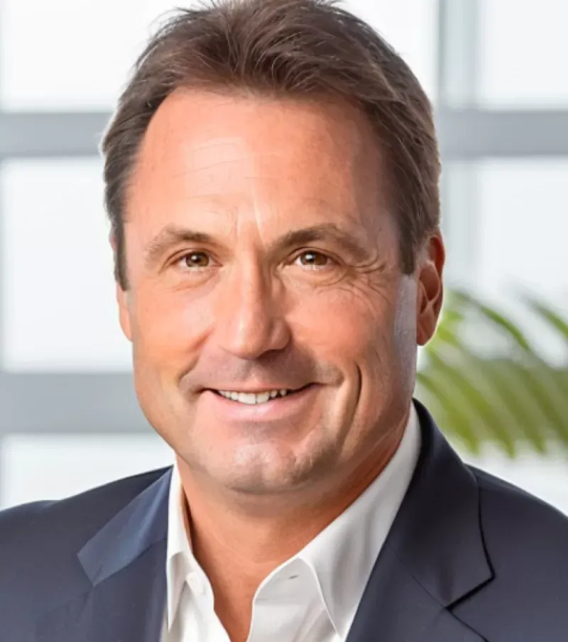 A man in a suit and white shirt smiles for the camera