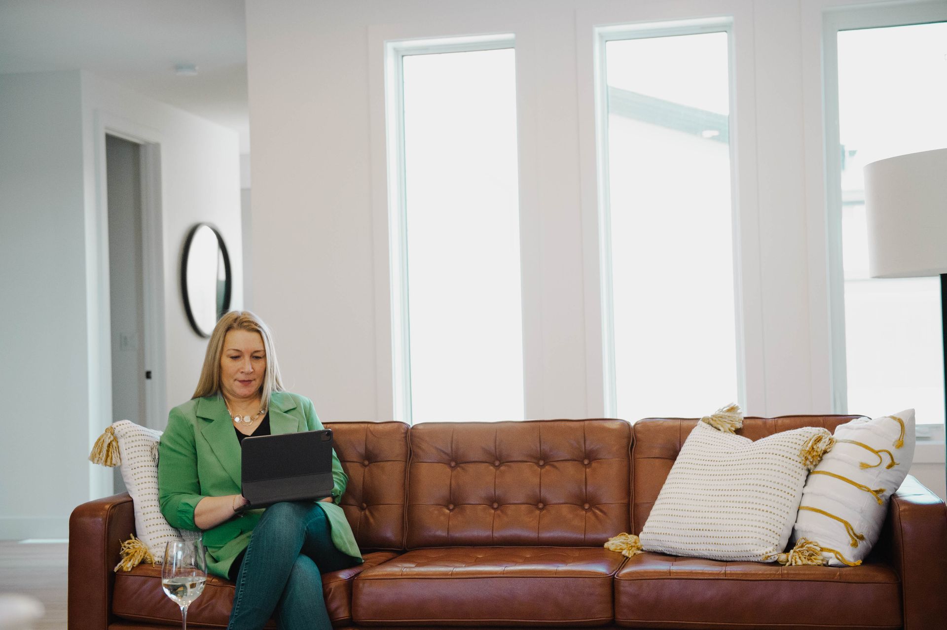 A woman is sitting on a couch using a laptop computer.