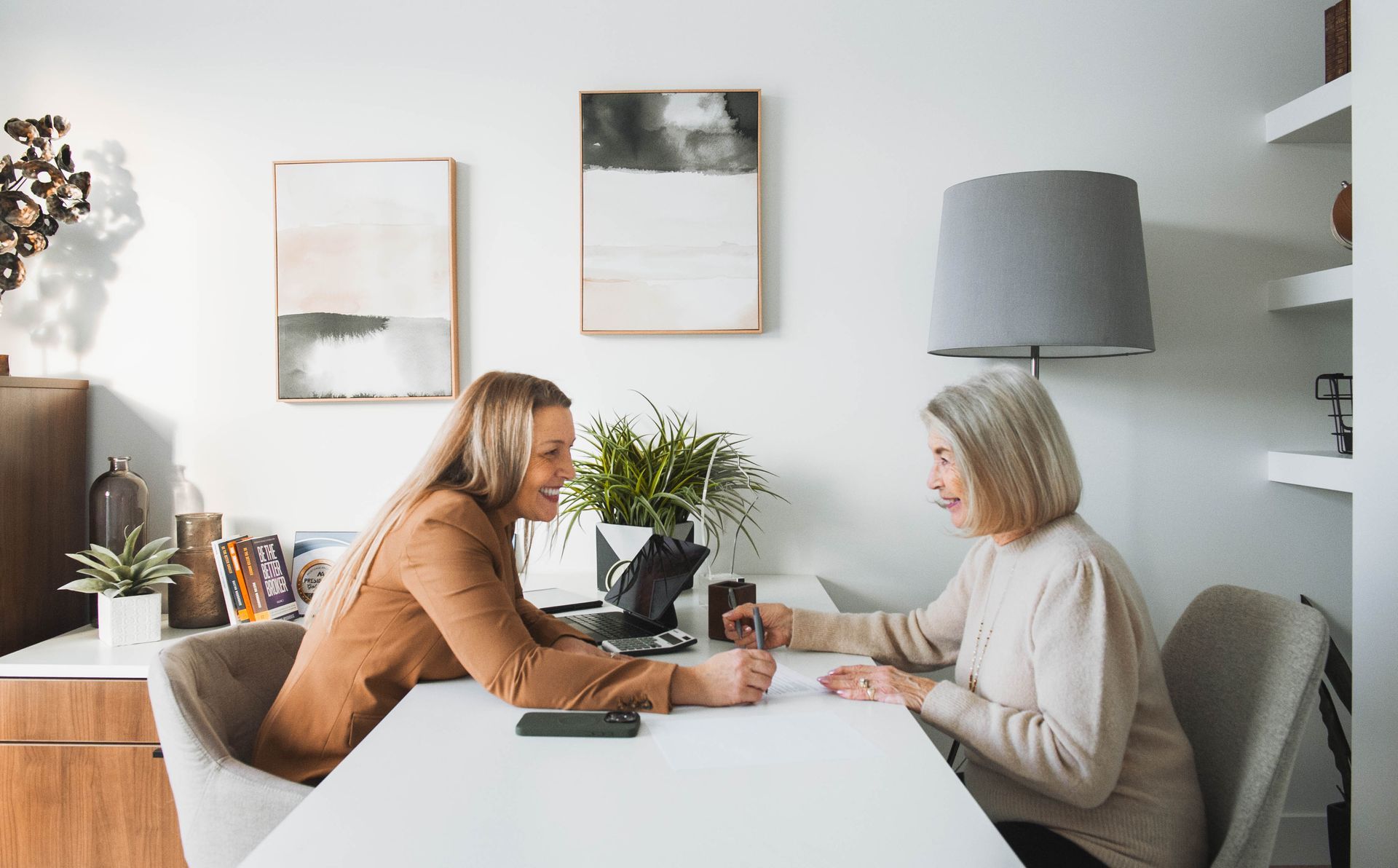 Two women are sitting at a table having a conversation.