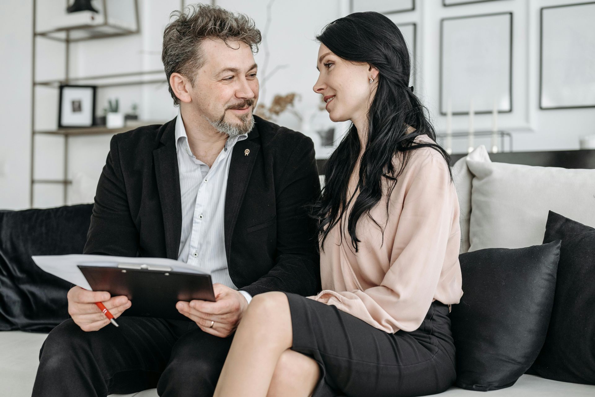 Two people on a sofa reviewing a tablet in a bright living room
